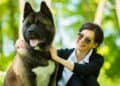 young woman smiling holding an adult Akita pet